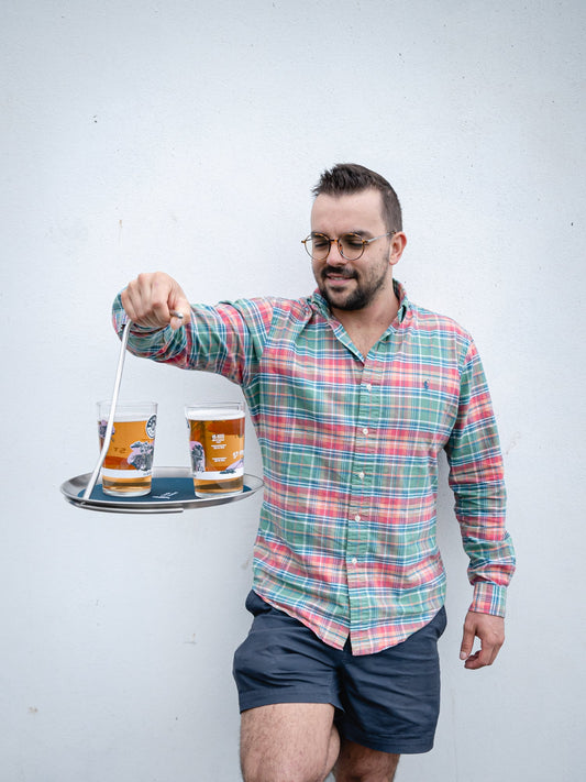 Man carrying two drinks on the Topple Tray with one hand