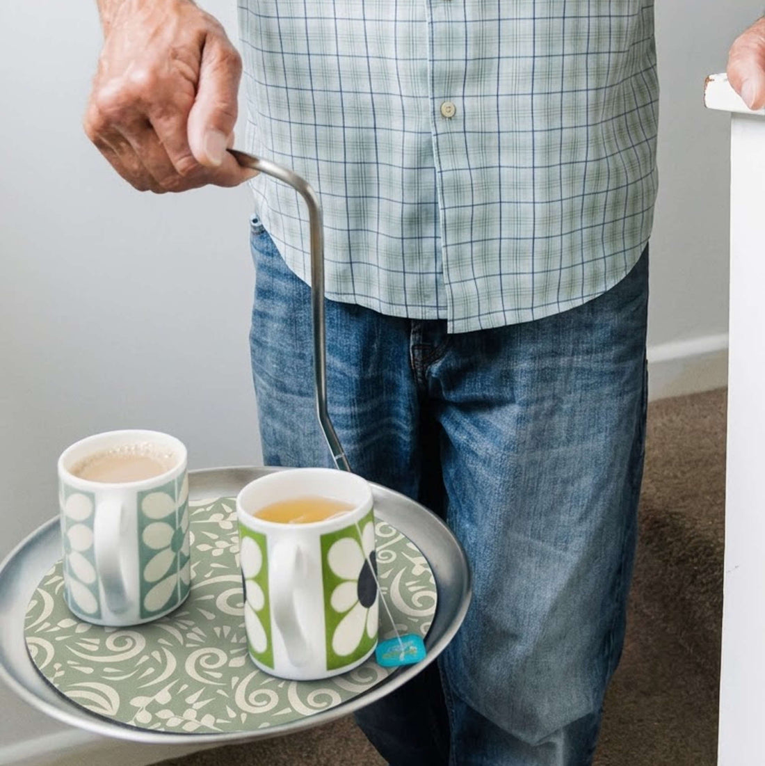 Pouring coffee into two mugs on the Topple Tray single-handed serving tray at home