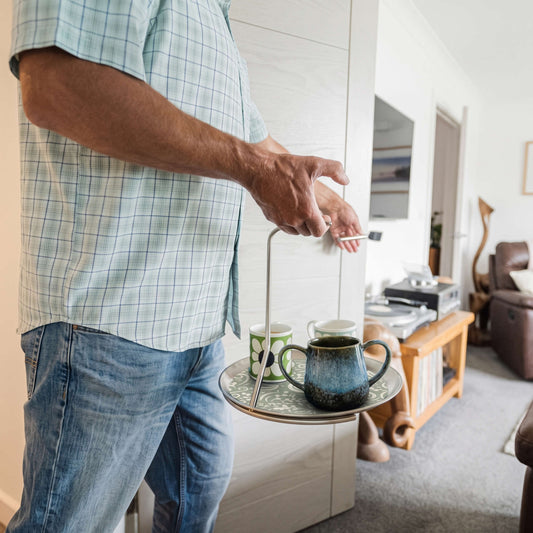 Carrying a teapot and mug through the living room on the Topple Tray with one hand